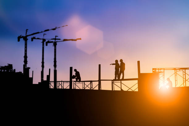 istock Silhouette of engineer and construction team working at site over blurred background for industry background with Light fair.Create from multiple reference images together 1150409557
