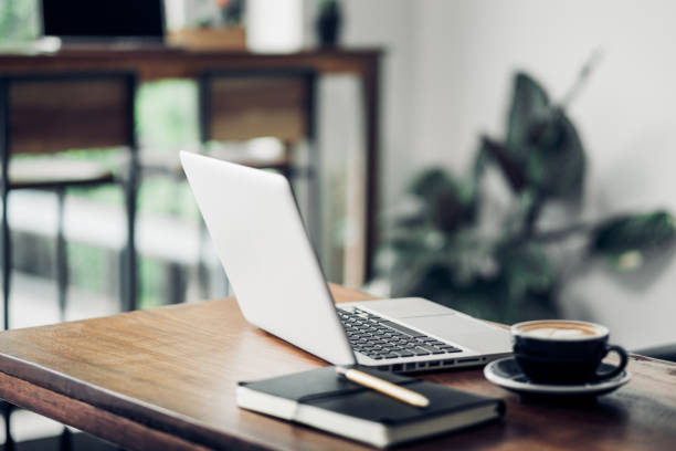 Laptop on wood table and coffee cup and notebook in cafe restaurant.digital technology lifestyle