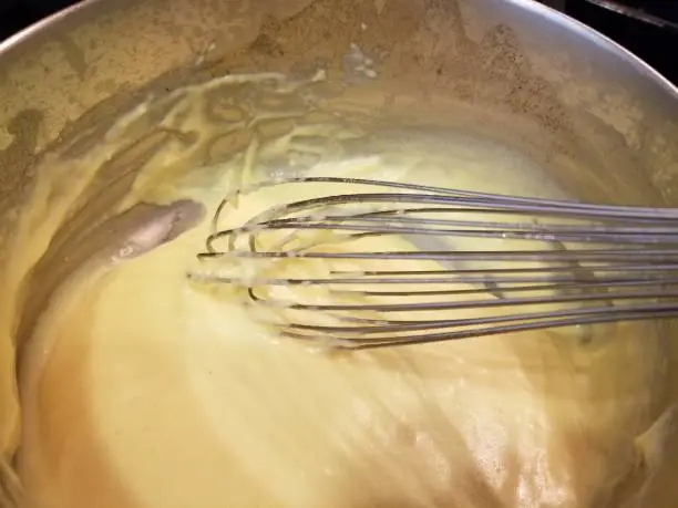 Close-up of metal mixing bowl where a wire whisk is being used to prepare a cheese sauce based on a roux, May 16, 2019. (Photo by Smith Collection/Gado/Getty Images)
