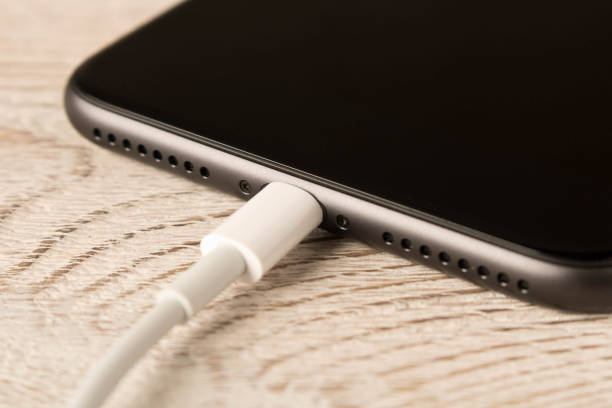 istock Smartphone on charge . On the  wooden table . Close up. 1150411040