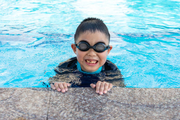 istock young boy swimming in pool. 1150413390