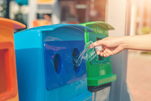 istock Dump the garbage into the blue tank for recycling. 1150415219