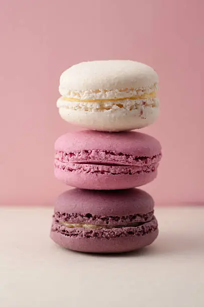 Photo of Stack of three pink macarons cookies on tile