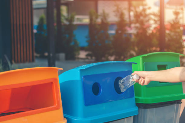 istock Dump the garbage into the blue tank for recycling. 1150415223