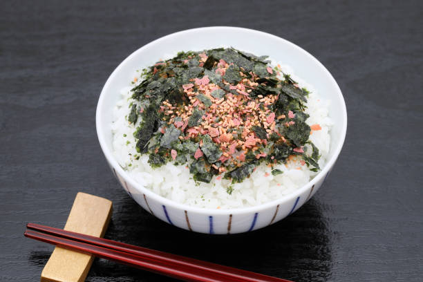 Japanese food, cooked rice with furikake of shake and nori on black background