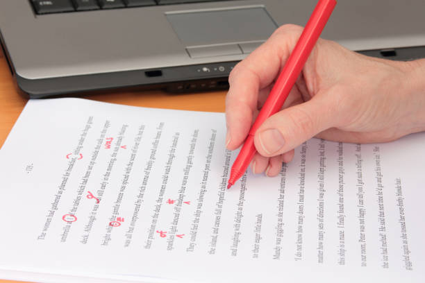 istock Hand Proofreading a Manuscript beside Laptop 1150422011