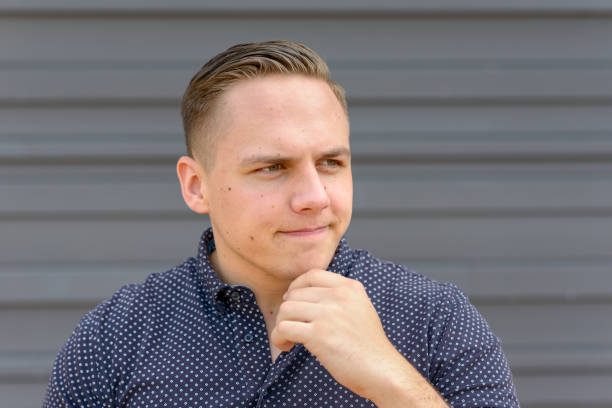 istock Thoughtful young man with his hand to his chin 1150424009