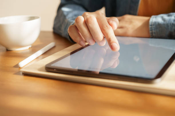 istock Asian women are playing tablets on the table. 1150425240
