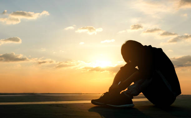 istock Young man sitting on floor are unhappy and stressed background sunset sky 1150426269