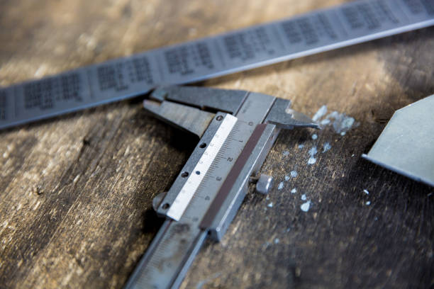 istock Vernier caliper and metal meter ruler on oil stained table, measuring tool 1150428628