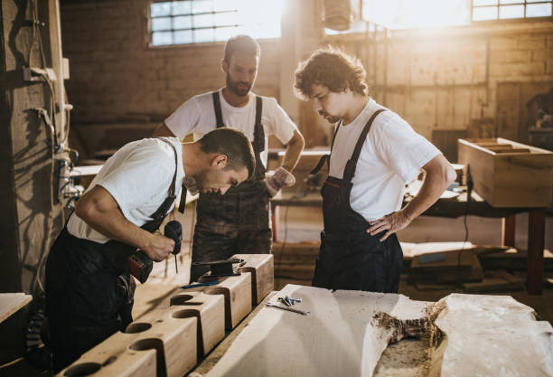 istock Group of carpenters cooperating while making furniture in a workshop. 1150429923