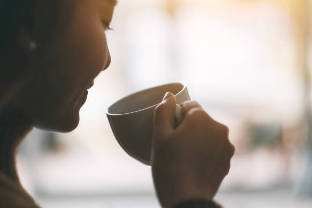 istock a beautiful woman holding and drinking hot coffee 1150430780