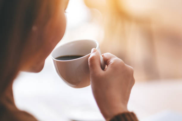 istock a beautiful woman holding and drinking hot coffee 1150430790