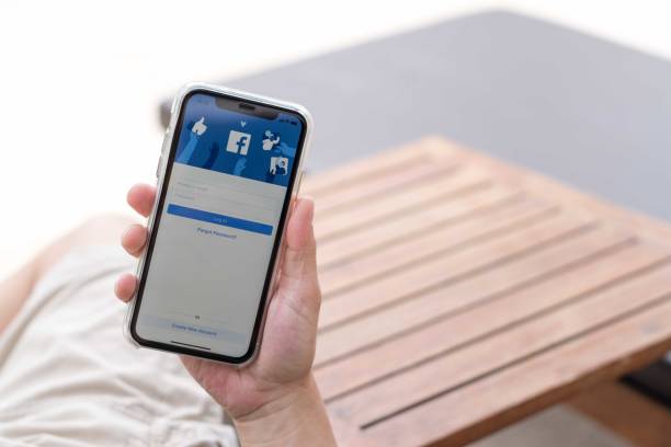 hand  using smartphone iphone xr with facebook application social media on screen, smart phone life style, mobile phone era in everyday lifestyle. - store application software iphone mobile phone imagens e fotografias de stock
