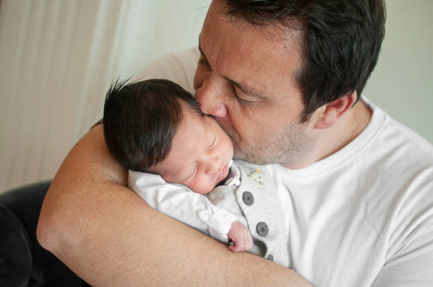 istock Young father holding his newborn baby boy 1150432681