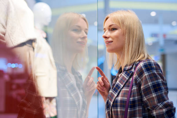 istock Young woman looking at window display 1150432696