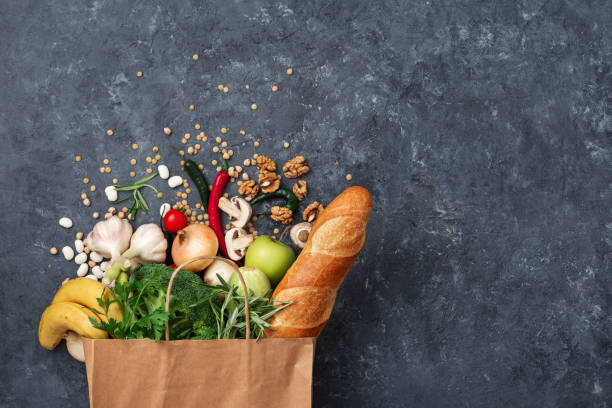 コピースペースのトップビューで暗い背景に野菜や果物と紙バッグ食品 - paper bag 写真 ストックフォトと画像