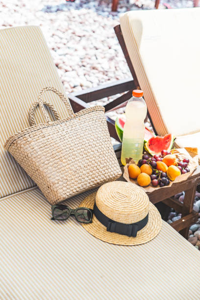 picnic in spiaggia. frutta fresca sul tavolo vicino alle lettini - beach table peach fruit foto e immagini stock