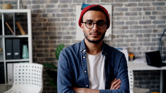 Slow motion portrait of male designer looking at camera and smiling in office