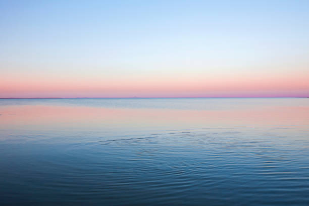 vague de mer au coucher du soleil - soft pink flash photos et images de collection