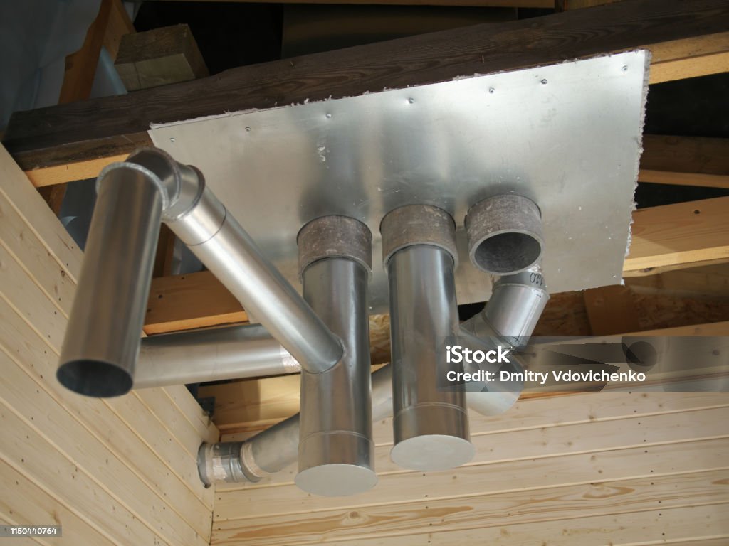 Whole house air ventilation and cleaning system. Ventilation metal pipes in silver insulation material and roof ferm. Whole house air ventilation and cleaning system. Ventilation metal pipes in silver insulation material and roof ferm Hand Fan Stock Photo