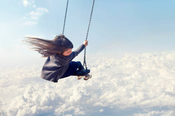 istock Little Girl Swinging Against Blue Sky 1150440848