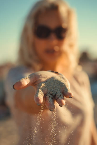 istock woman holding sand in her hands. 1150443720