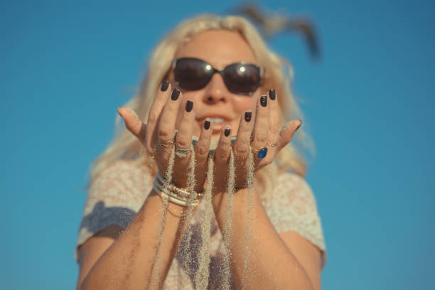 istock woman holding sand in her hands. 1150444193