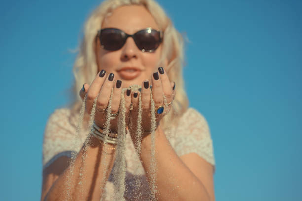 istock woman holding sand in her hands. 1150444813