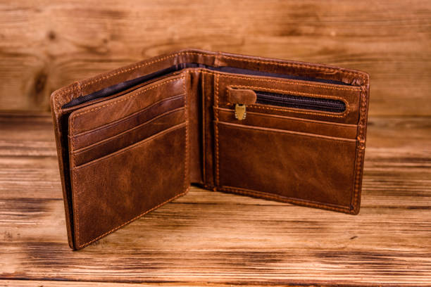 istock Opened brown leather wallet on wooden table 1150445181
