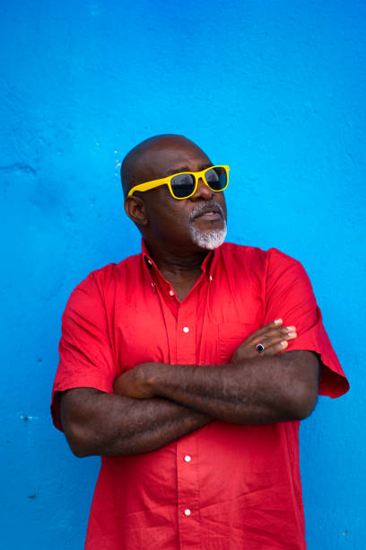 istock Mature man with sunglasses standing arms crossed on colored background 1150447632