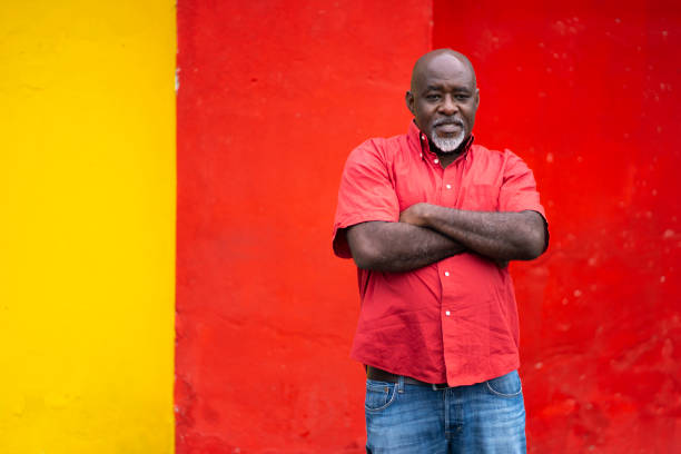istock Mature man standing arms crossed on colored background 1150447634