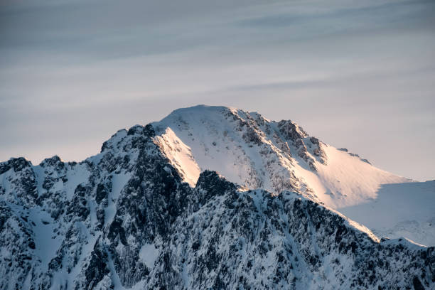 istock Summit of snow mountain with sunrise shining 1150450347