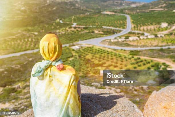 A Lonely Muslim Woman Traveler In A Colorful Scarf Sits On Top Of A Mountain Stock Photo - Download Image Now