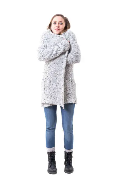 Photo of Freezing cold young woman covering with cardigan in winter fashion.