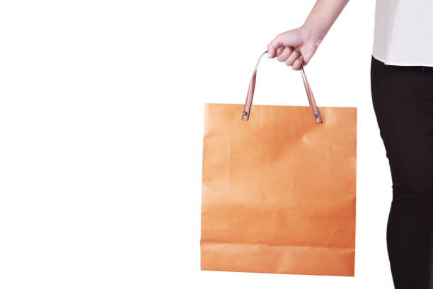 Cropped portrait image of young lady holding shopping bag isolated on white, commerce consumerism concept