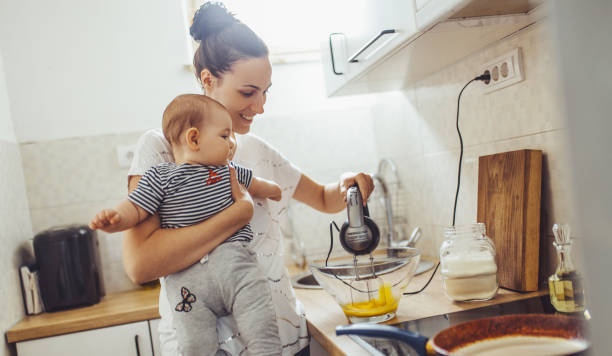istock Single mother working at kitchen. Young mother making pancakes. 1150453803