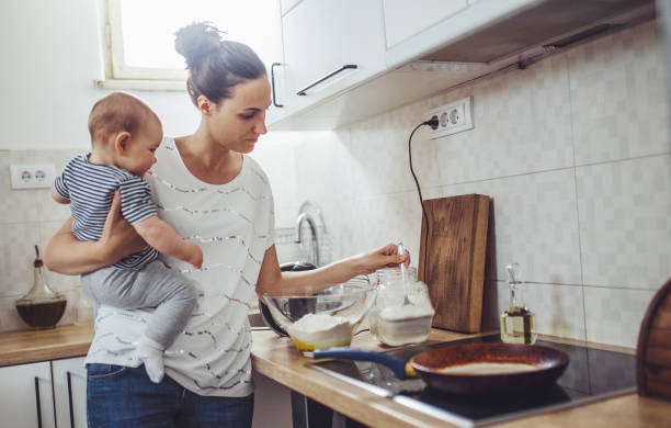 istock Single mother working at kitchen. Young mother making pancakes. 1150453863