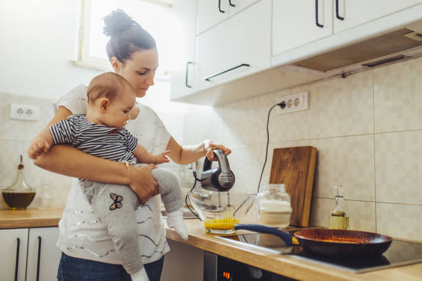 istock Single mother working at kitchen. Young mother making pancakes. 1150453920