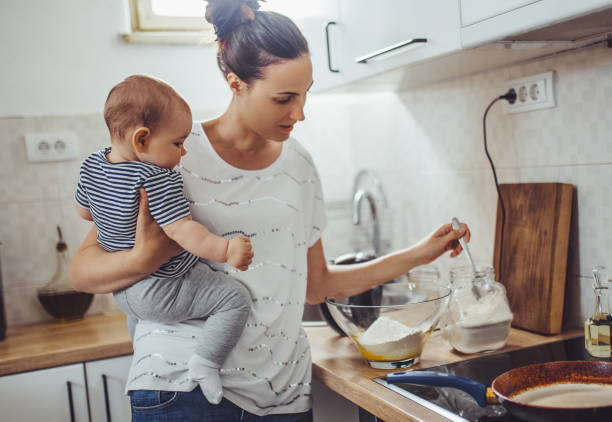 istock Single mother working at kitchen. Young mother making pancakes. 1150454062