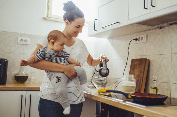 istock Single mother working at kitchen. Young mother making pancakes. 1150454066