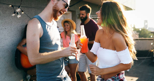 istock Friends having fun and drinking outdoor on a rooftop get together 1150454117