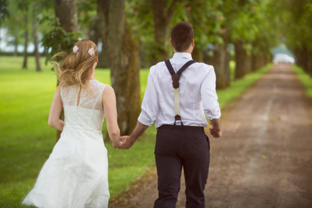 istock Bride and groom running from wedding 1150455156