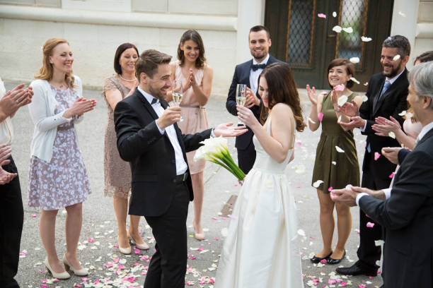 istock Guests throwing rose petals on bride and groom 1150455176