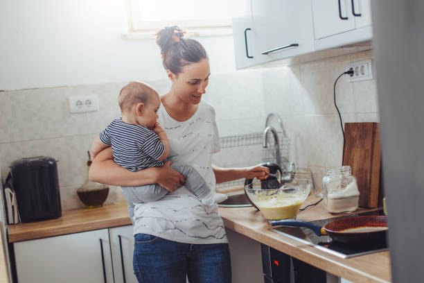 istock Single mother working at kitchen. Young mother making pancakes. 1150455235