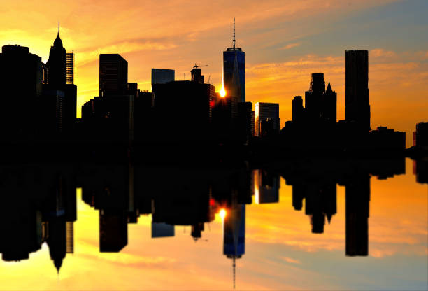 Manhattan downtown skyline in lower manhattan financial district with modern skyscrapers over river with water reflections. New York