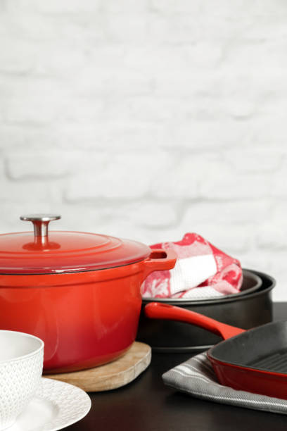 istock Cookware set: Red enameled cast iron pot, saucepan and bowls 1150458847