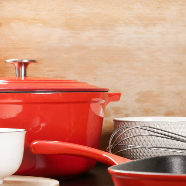 istock Cookware set: Red enameled cast iron pot, saucepan and bowls 1150458956