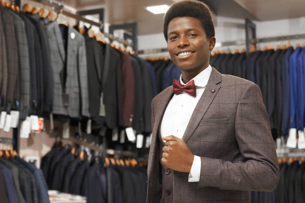 istock Smiling african man posing in boutique in grey suit. 1150459276