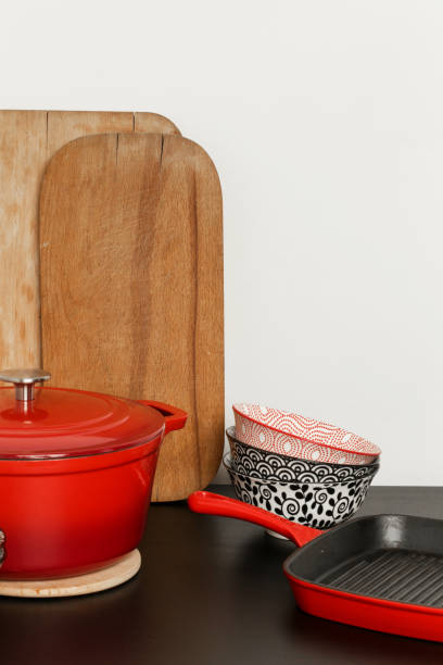 istock Cookware set: Red enameled cast iron pot, saucepan and bowls 1150459313